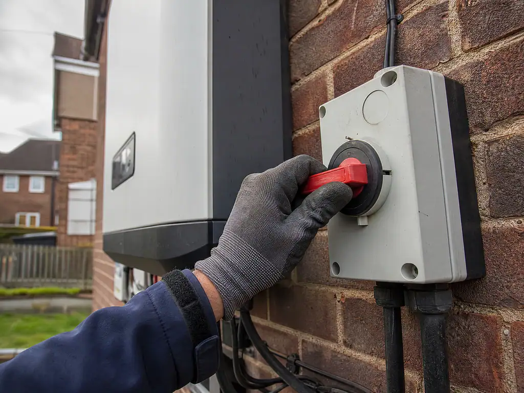 Engineer checking the DC isolator during a solar service, Birmingham