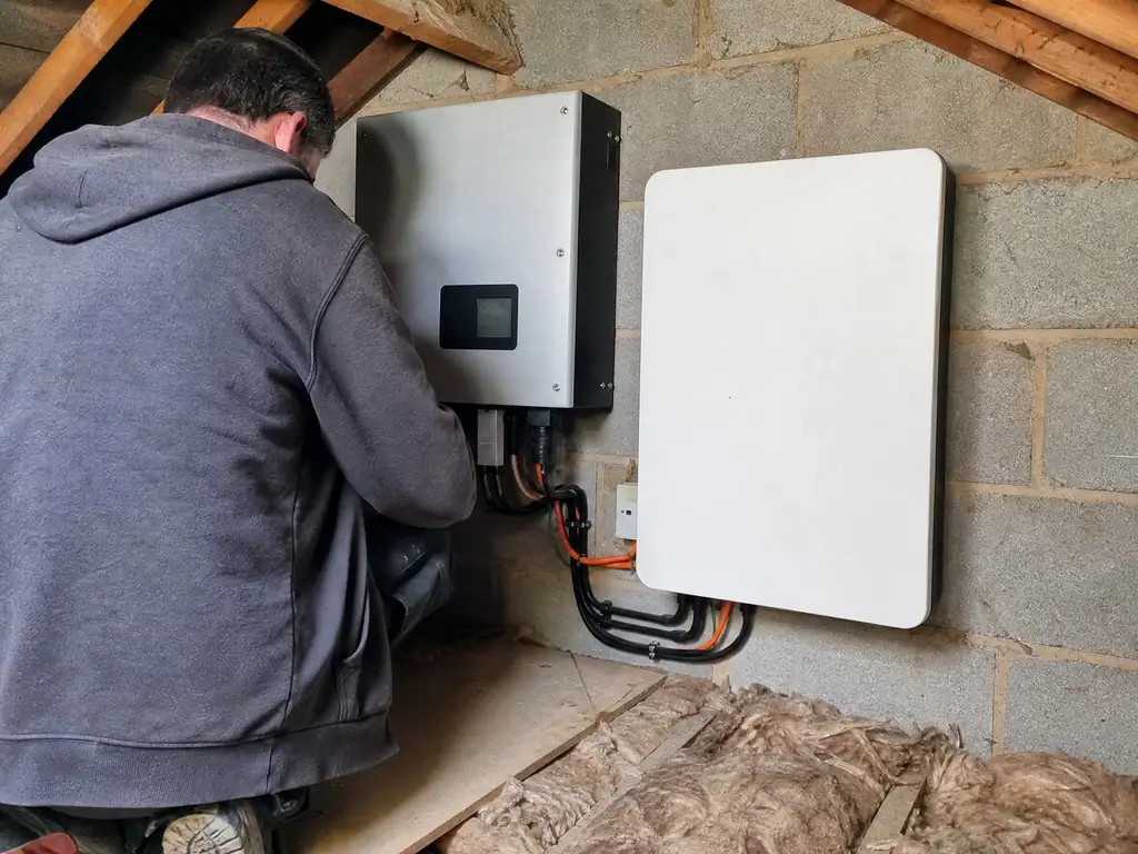 New battery fitted beside an older solar inverter in a loft, Birmingham